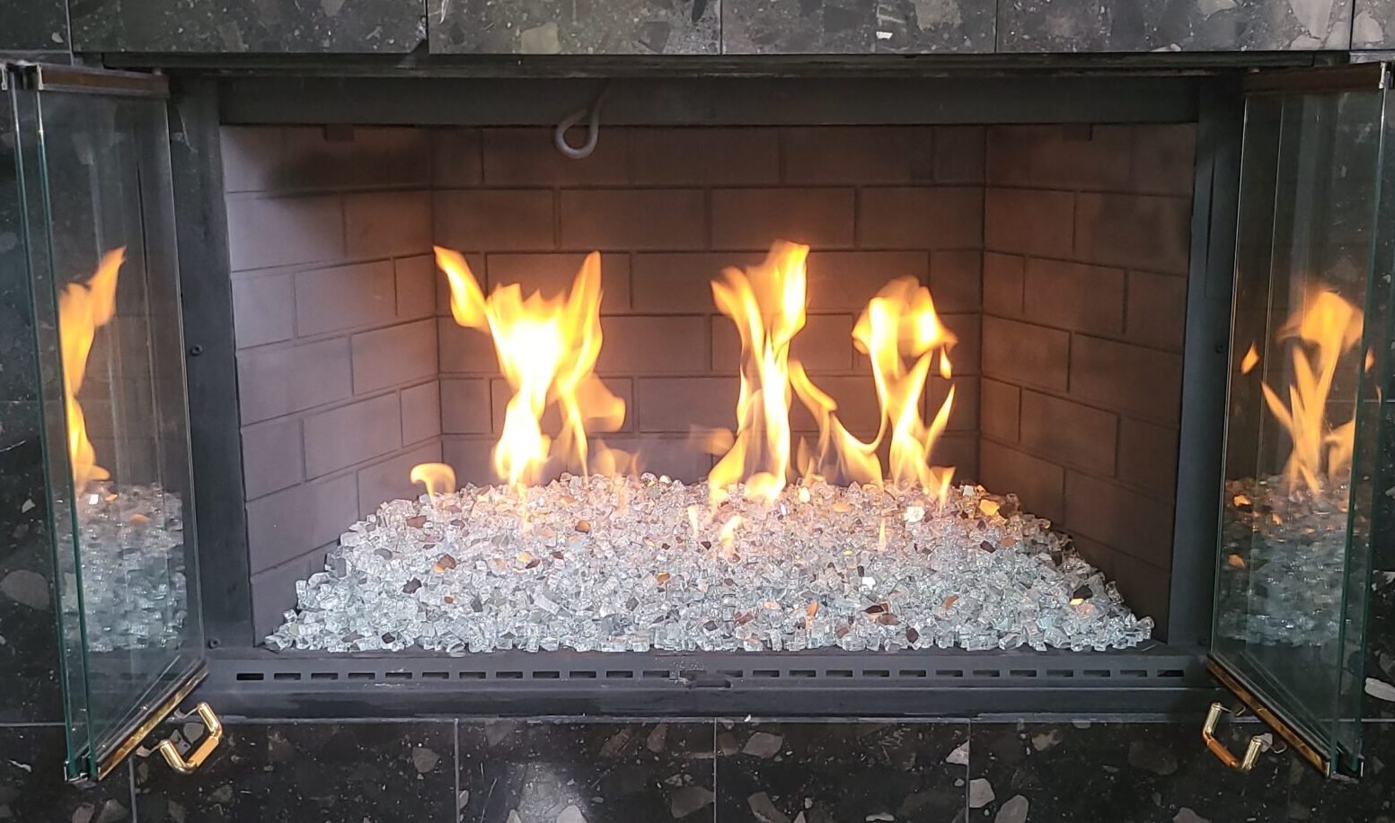 gas fireplace serviced with white fire glass installed with new burner in Coppell, Texas