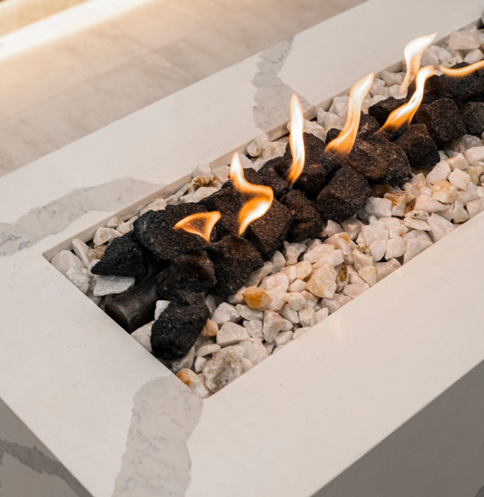Close-up of a modern indoor gas fireplace with flames and decorative stones installed in Dallas, texas