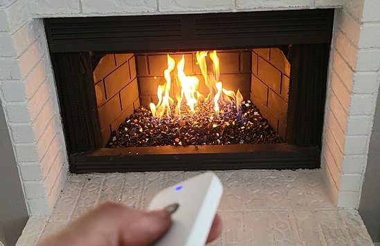 Projects gas fireplace with remote start system with black fire glass in Plano, Texas